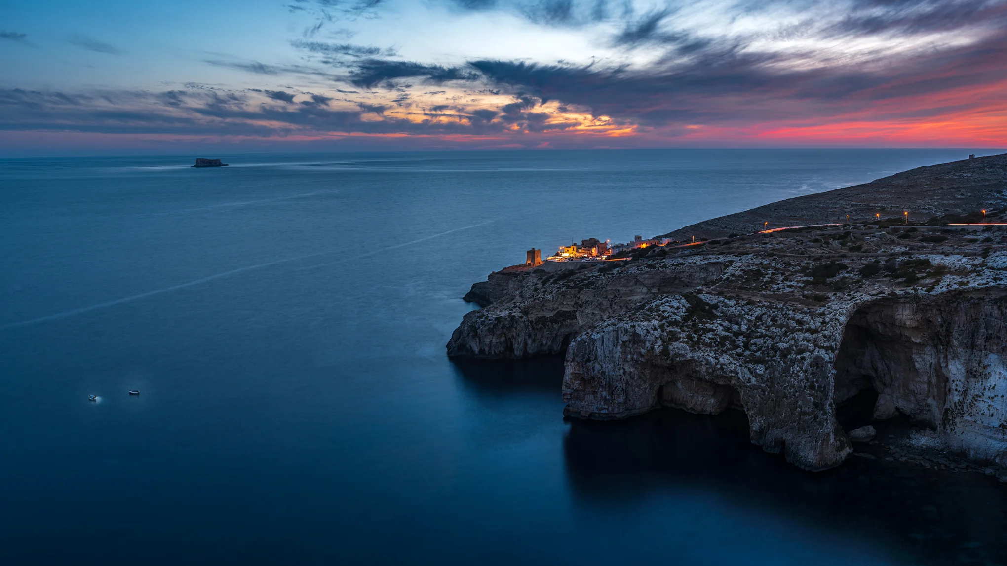 Blue Grotto panorama at sunset, Malta. Fishing boats on dark water
